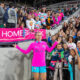 Alex Morgan standing in front of a group of fans in the stands and a sign that says Homebreak.