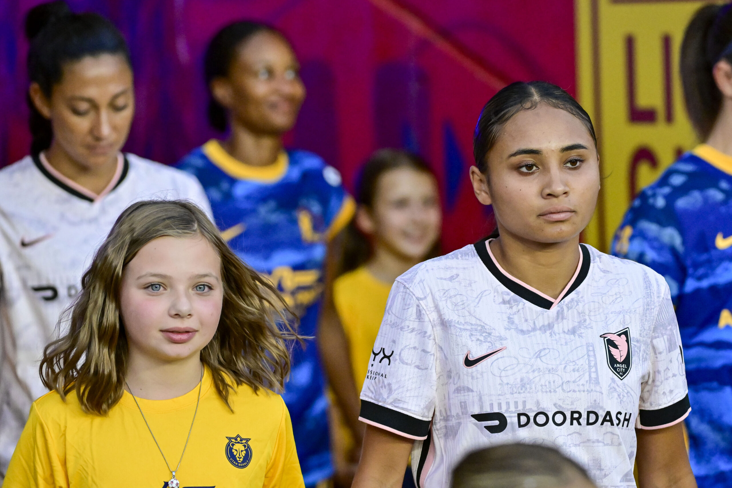 Alyssa Thompson waits with a mascot to exit the tunnel before Angel City's match against the Utah Royals in Sandy, Uutah on August 15, 2025.